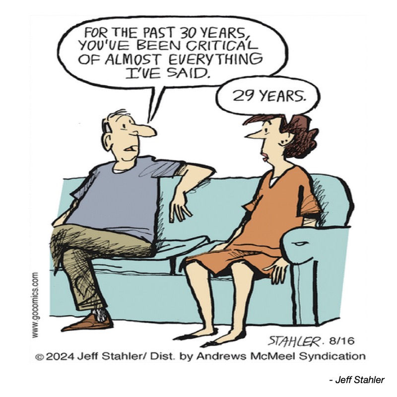 A man and woman sit on a couch; he claims she's been critical for 30 years, she corrects him to 29.