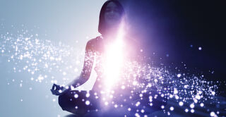 A person sits in a meditative pose, surrounded by glowing particles and light emanating from their center.